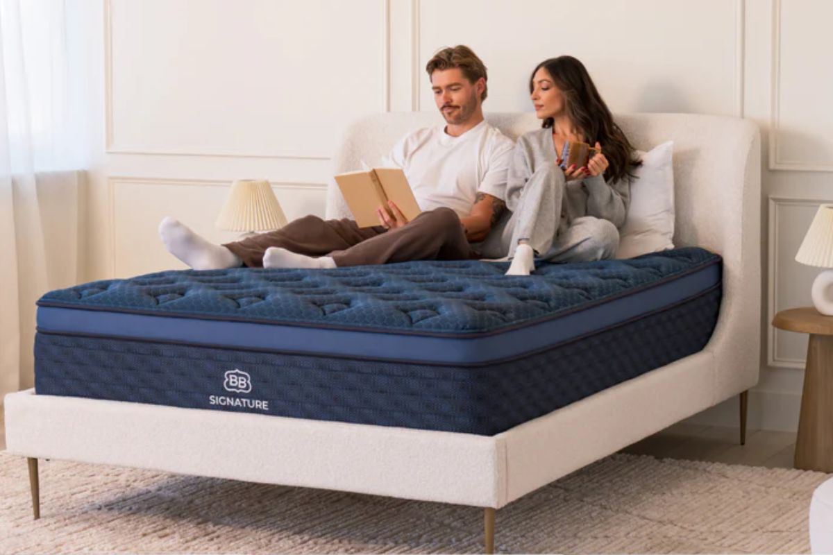 A couple sitting up on the The Brooklyn Bedding Signature Hybrid.