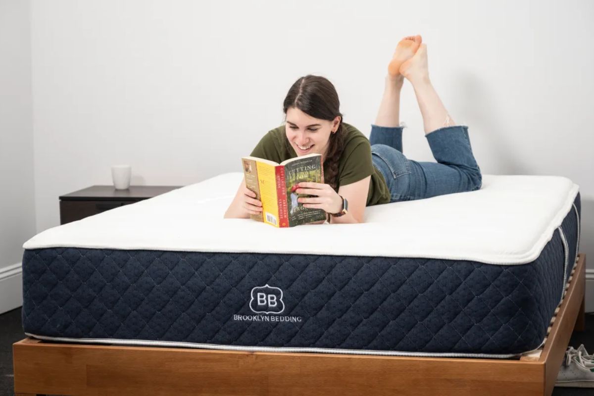 Person lying on Brooklyn Bedding Signature Hybrid mattress testing comfort at home during trial period