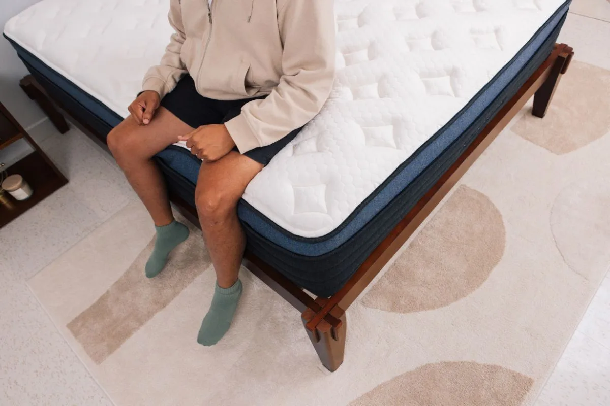 A man sitting on the edge of a bed.