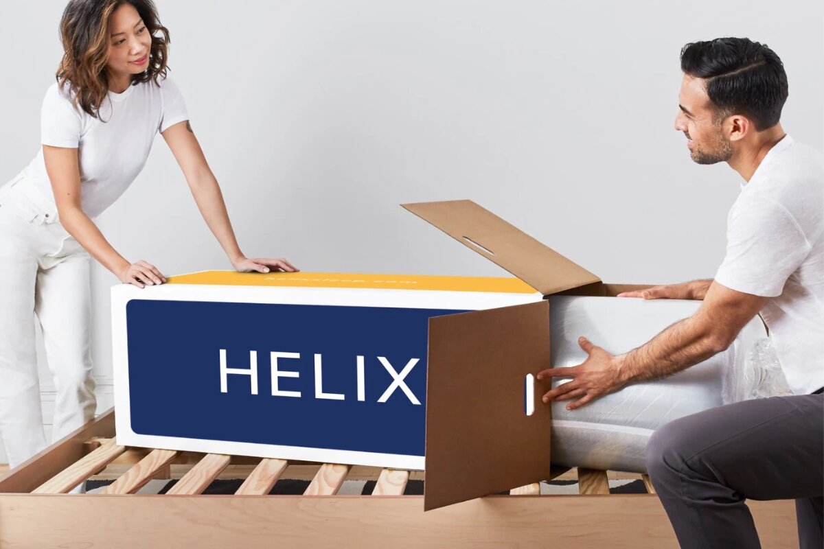 couple unboxing Helix mattress together on wooden bed frame