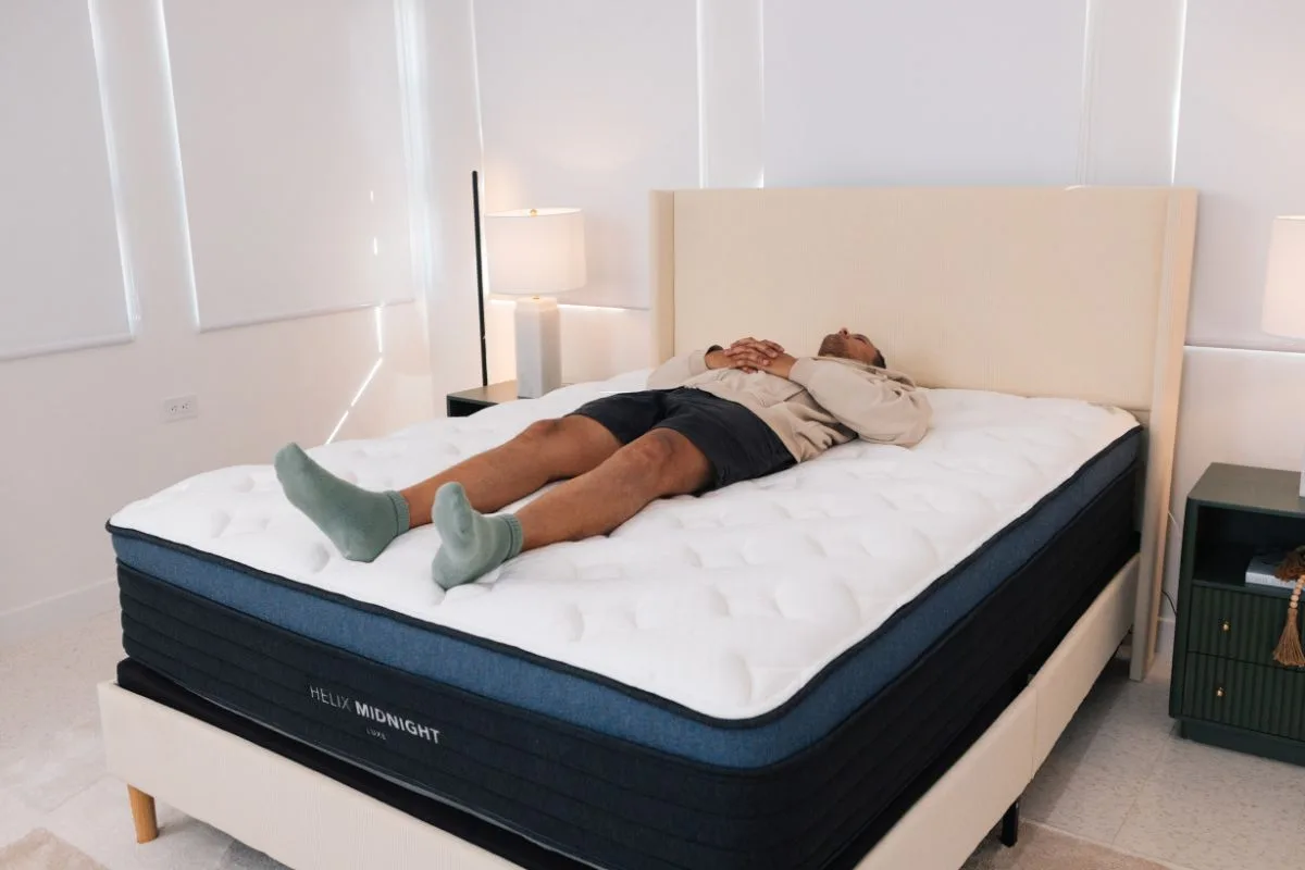 A man on the Helix Midnight Luxe in a bedroom.