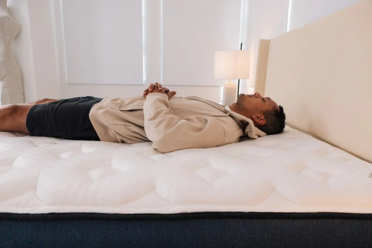 A man on the Helix Midnight Luxe in a bedroom.