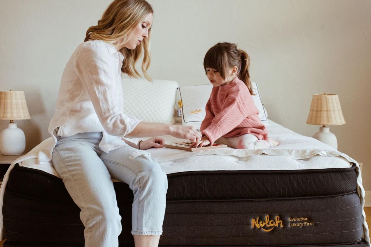 Mother and child sitting on Nolah Evolution 15 mattress highlighting safe materials for family use
