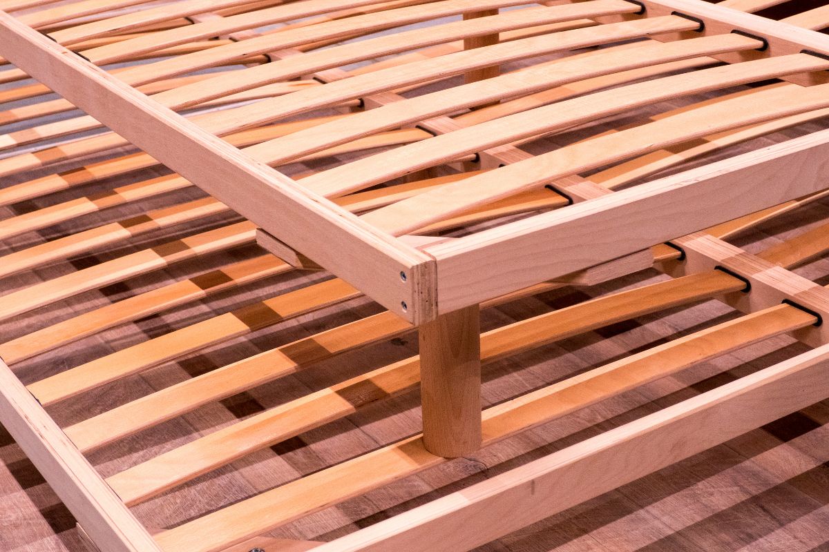 Wooden bed frame with slats showing support structure for a king size mattress