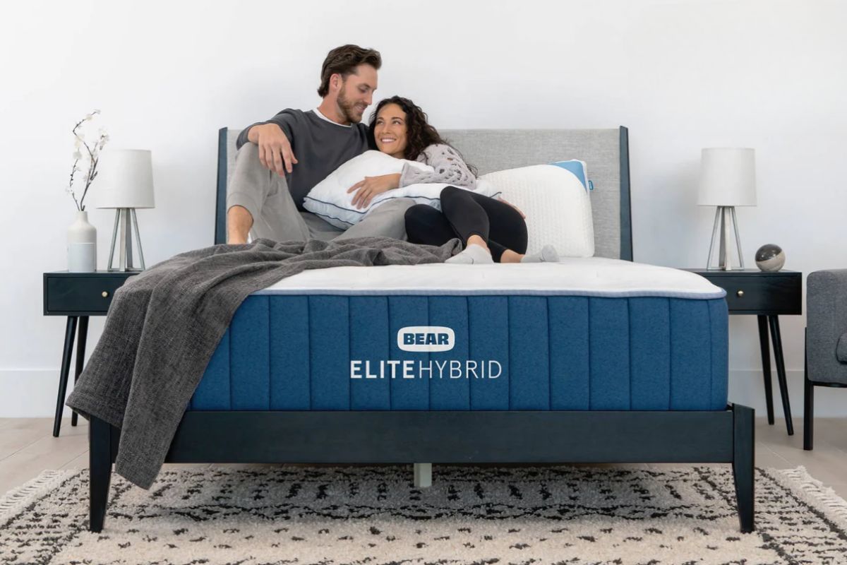 Couple relaxing on Bear Elite Hybrid mattress showing comfort before initiating a return