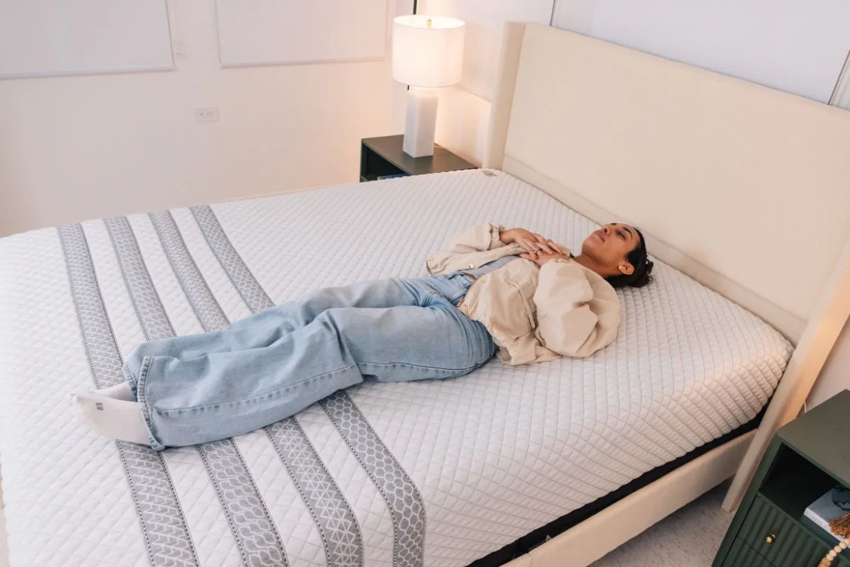 A woman lying down on the Leesa Sapira Hybrid.