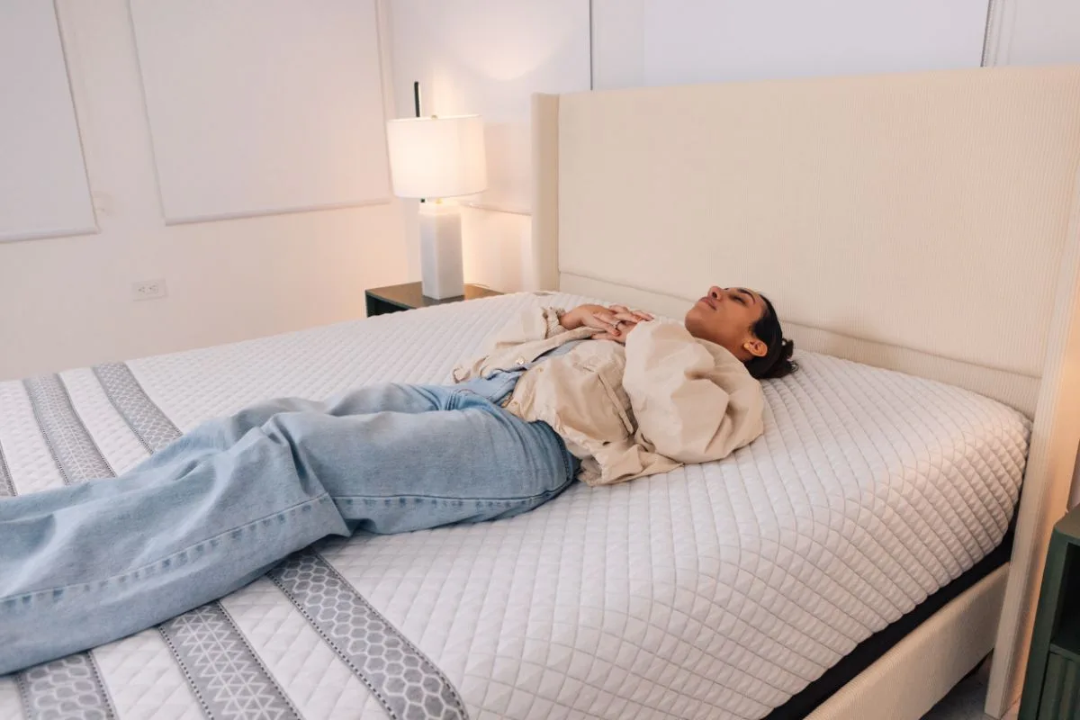 A woman lying down on the Leesa Sapira Hybrid Mattress.