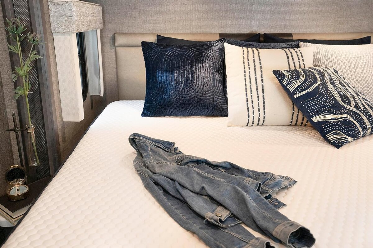 Brooklyn Bedding Aurora Luxe Cooling mattress surface with pillows and folded jeans showing clean sleep area