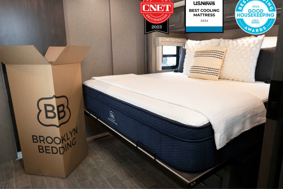 Brooklyn Bedding Aurora Luxe Cooling mattress set up on bed next to shipping box with award badges displayed