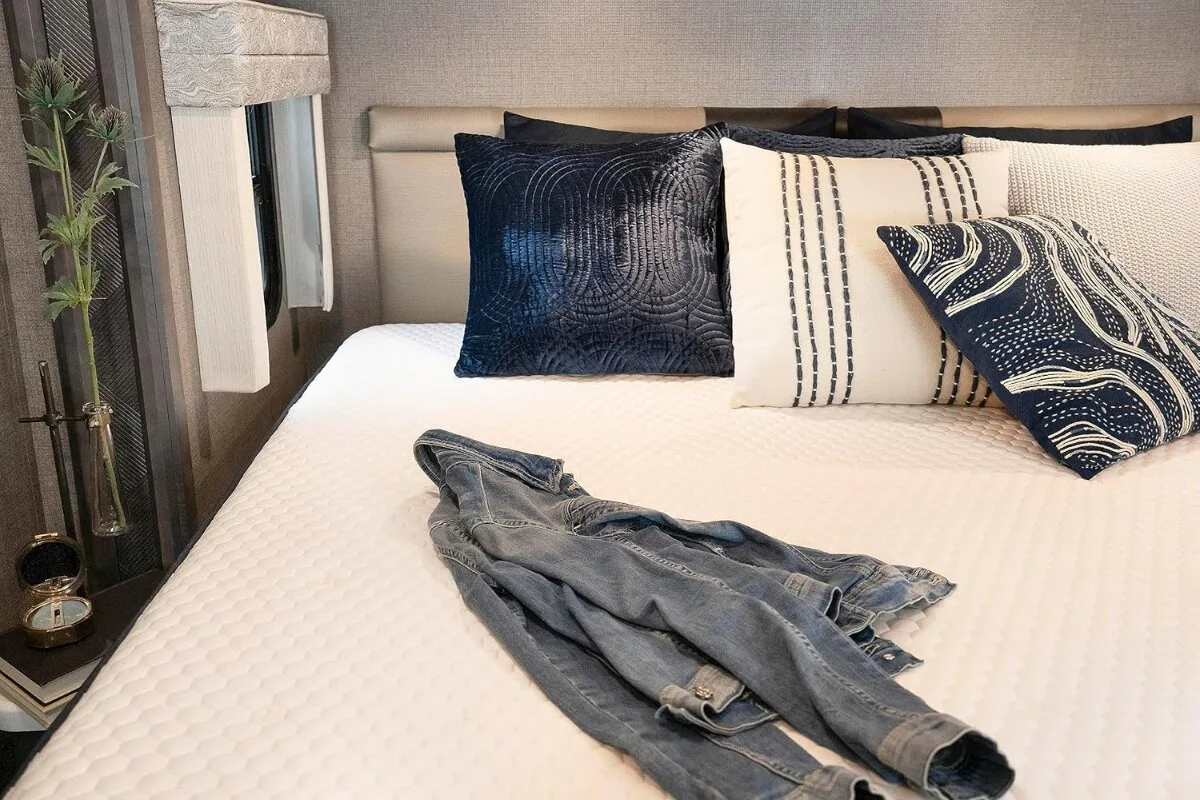 brooklyn bedding aurora luxe cooling mattress with pillows and folded clothing on top