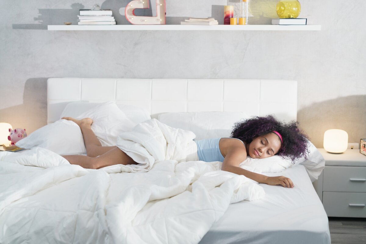 modern bedroom with white bedding and woman sleeping comfortably on soft mattress