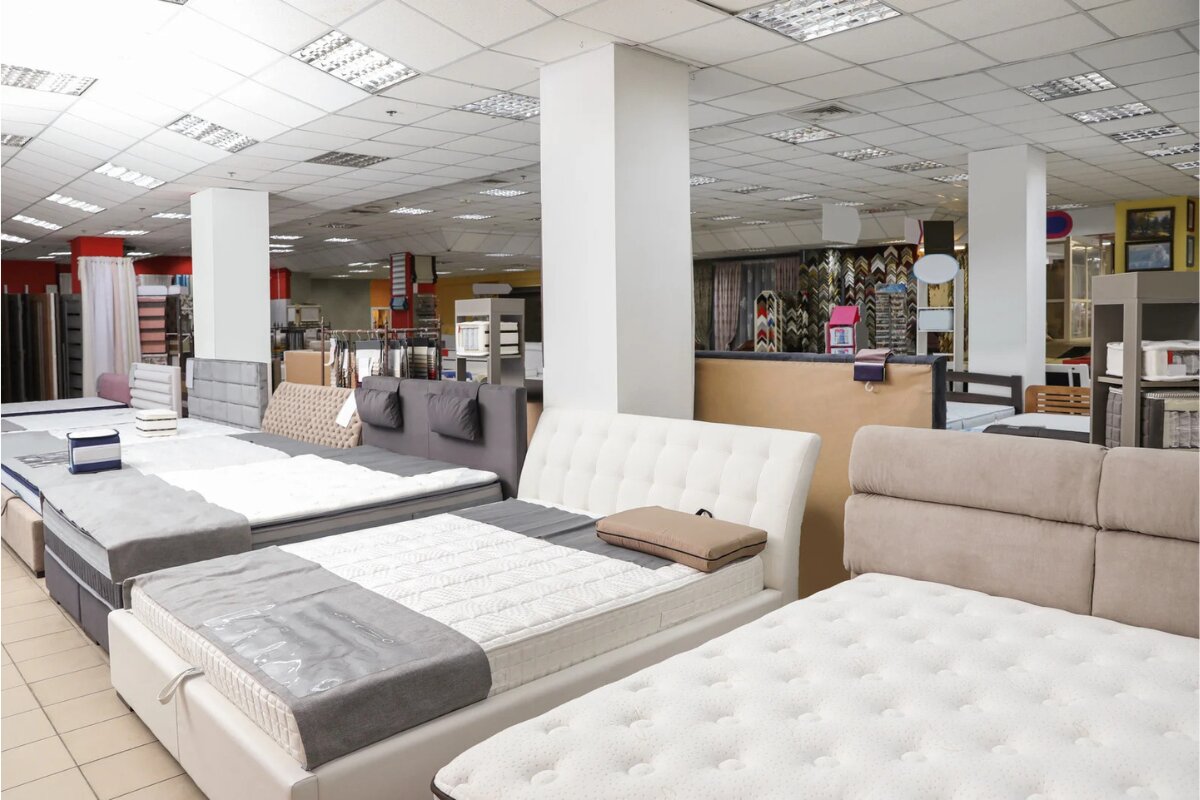 mattress showroom with multiple king-size beds and headboards on display