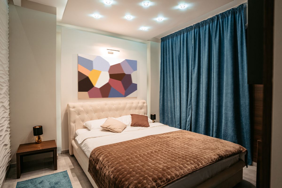 Modern bedroom with a queen bed illustrating typical width and room fit