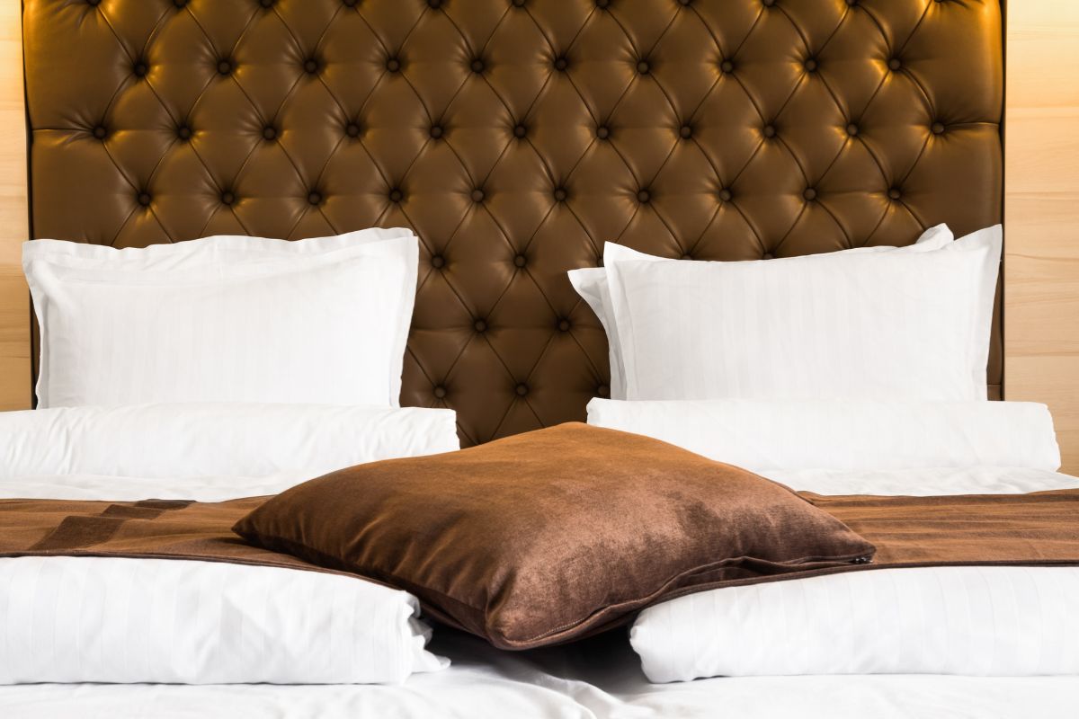 Close-up of a queen bed headboard and pillows highlighting width across the mattress