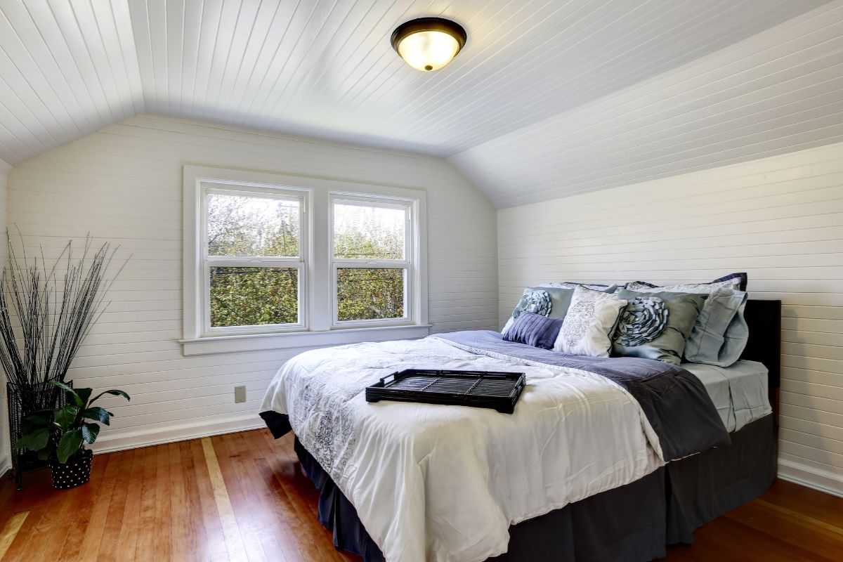 Queen bed in a bright bedroom showing overall width and layout within the space