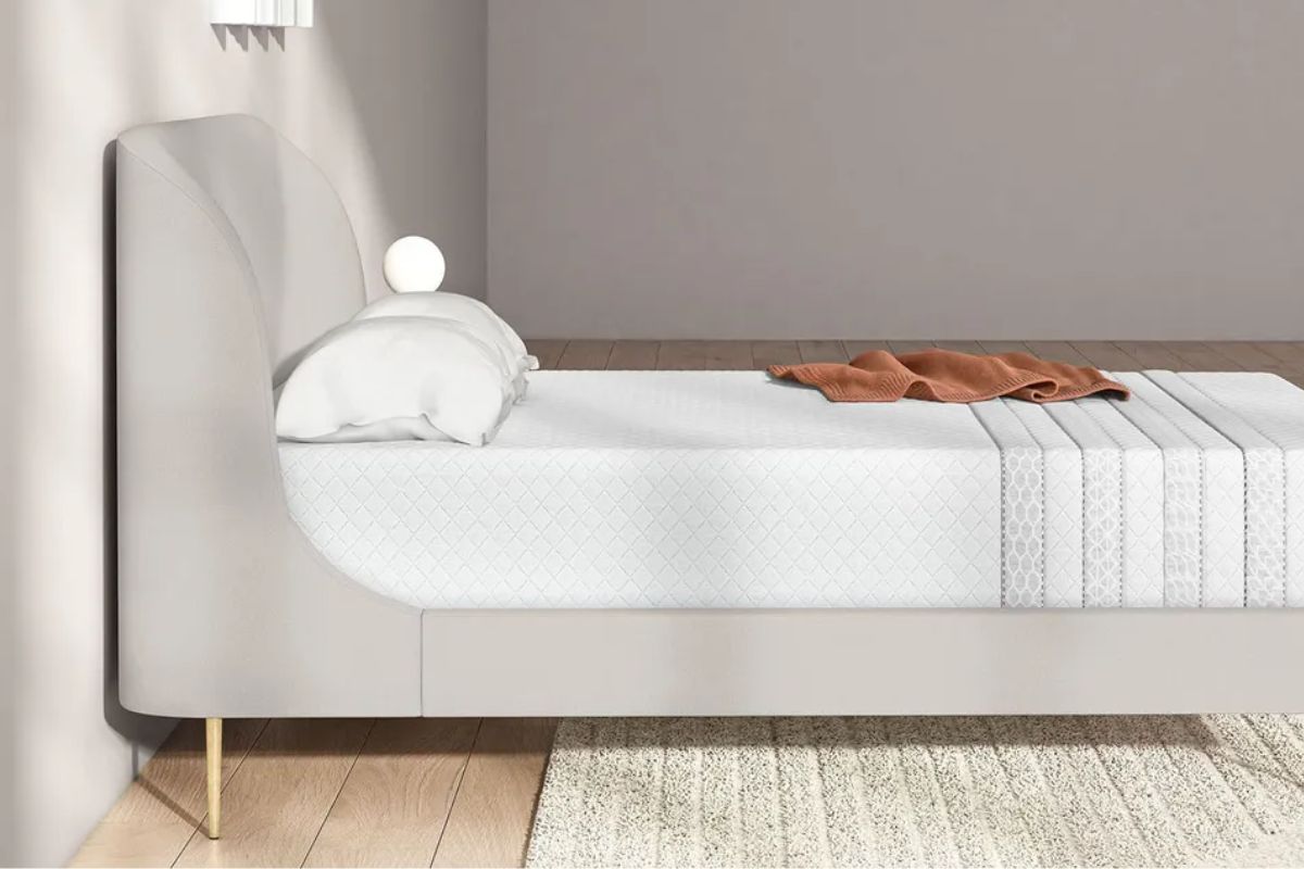 A side profile of a bed with a pillow and brown blanket.