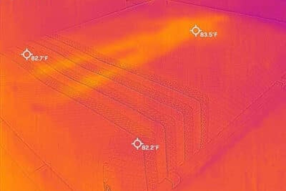 A heat image of a bed where you can barely see an outline of a person.