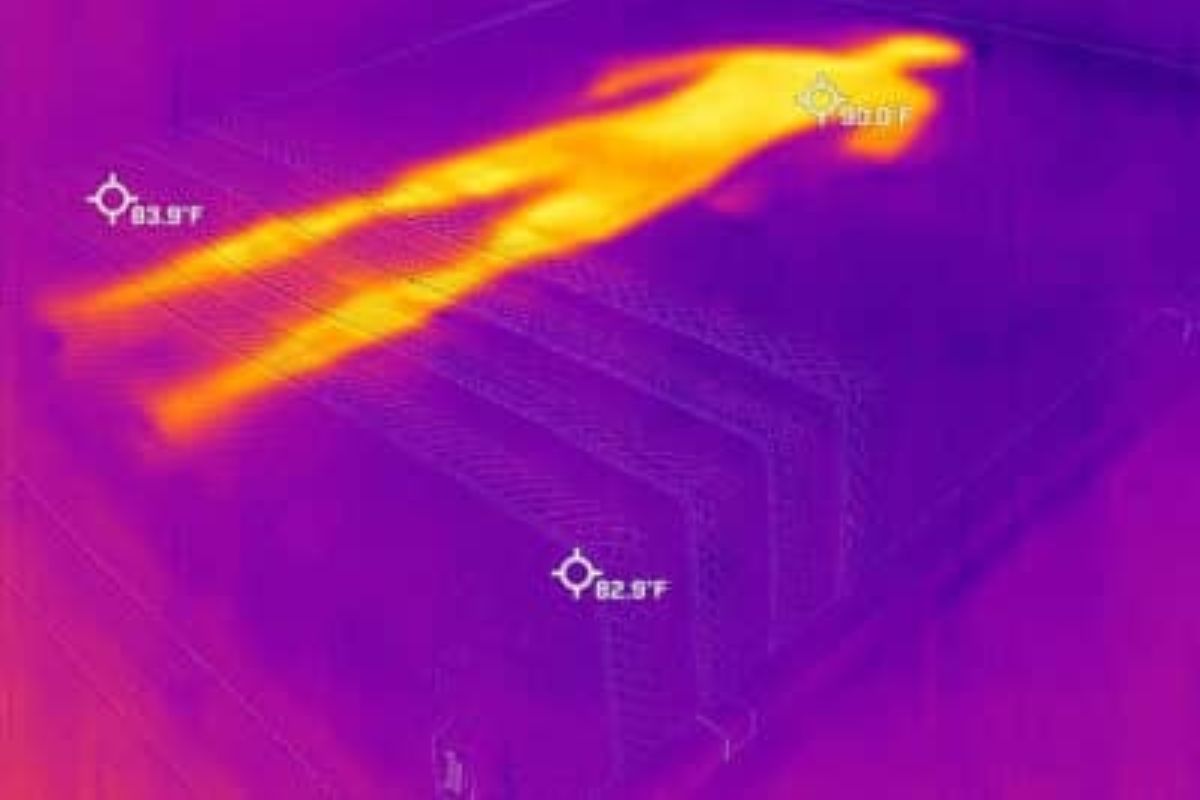 A heat image of a bed where you can see an outline of a person.