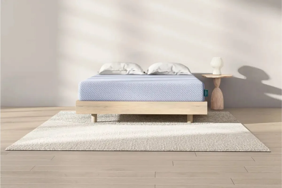 Leesa Sapira Hybrid mattress close-up showing quilted surface with icons highlighting 10-year warranty, USA assembly, and free delivery