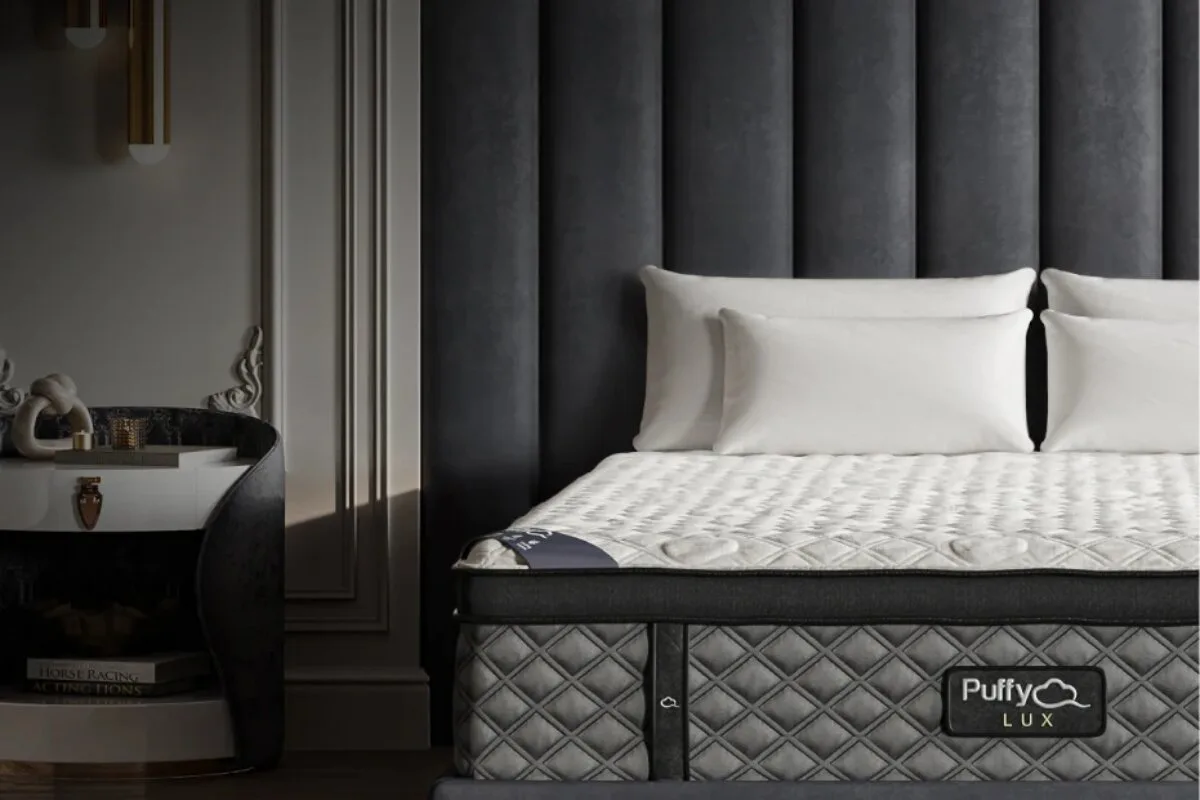 Puffy Lux mattress with quilted cooling top and branded side panel on upholstered bed frame