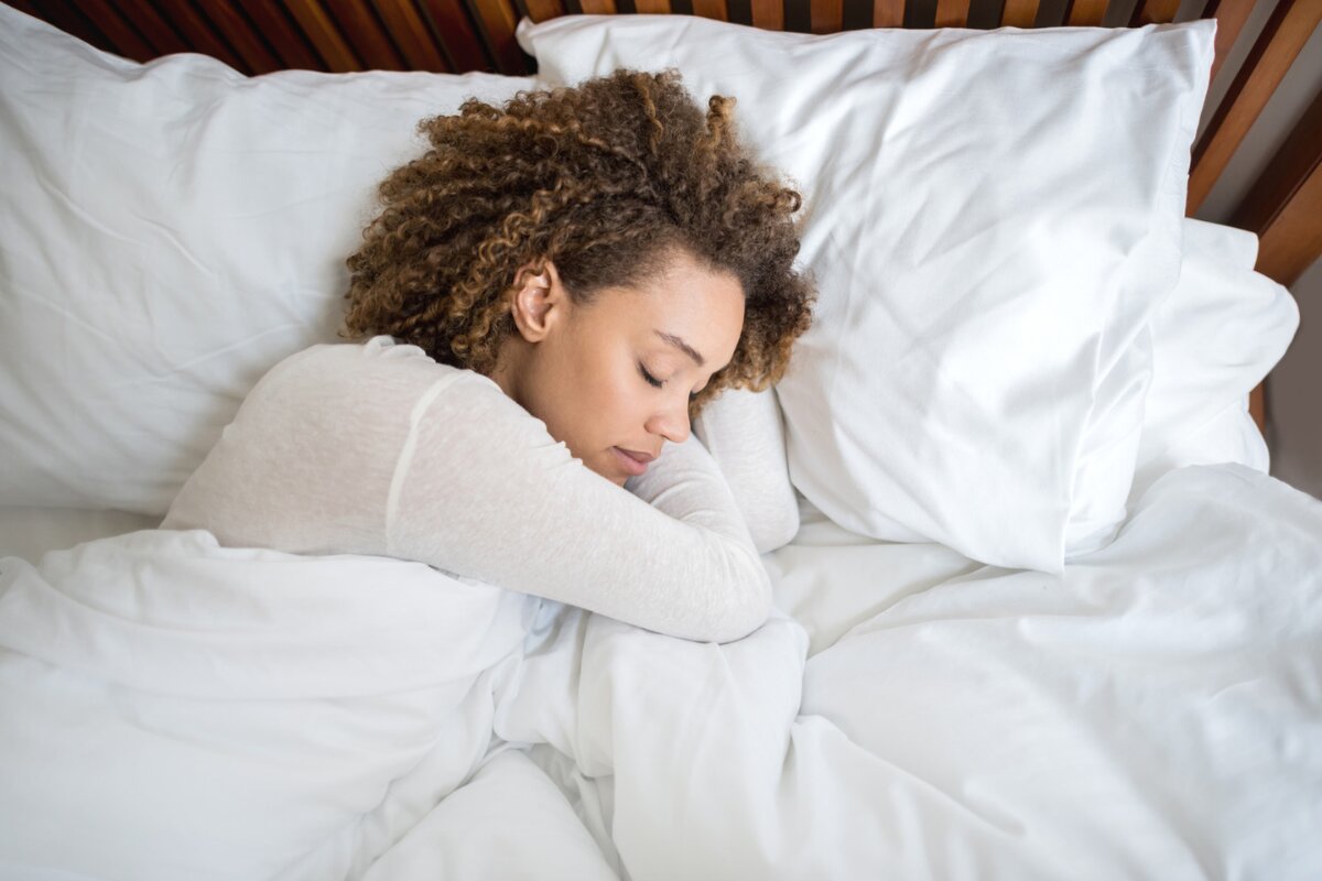 person sleeping comfortably on a california king mattress with soft white bedding