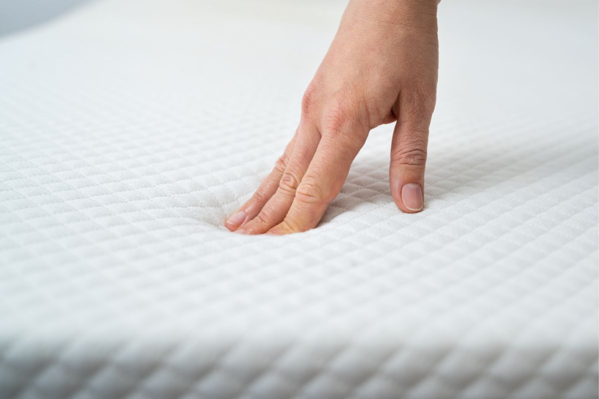 What is a Partial Split King Mattress? Hand pressing into mattress surface to demonstrate pressure relief and comfort in a partial split king mattress