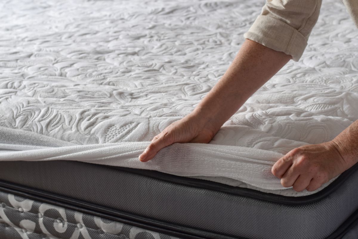 Lifting a mattress corner to show layers and construction used in split California king mattresses