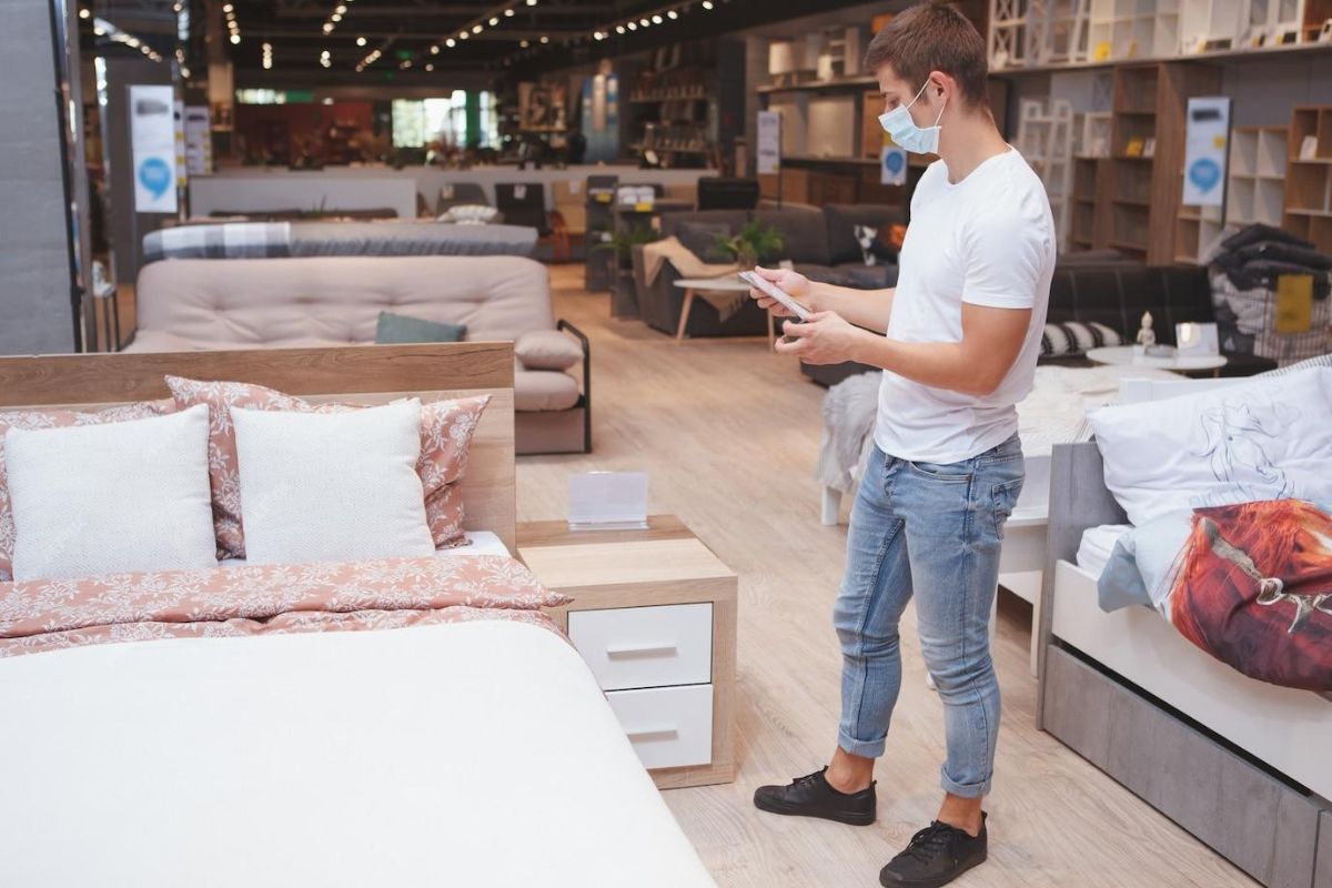 Shopper browsing mattresses in store while comparing where to buy a California King mattress