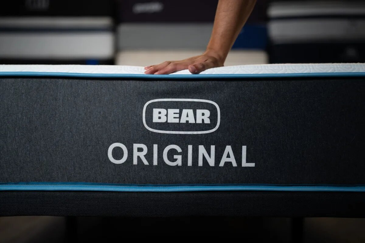 hand pressing down on bear original mattress to demonstrate foam support and firmness