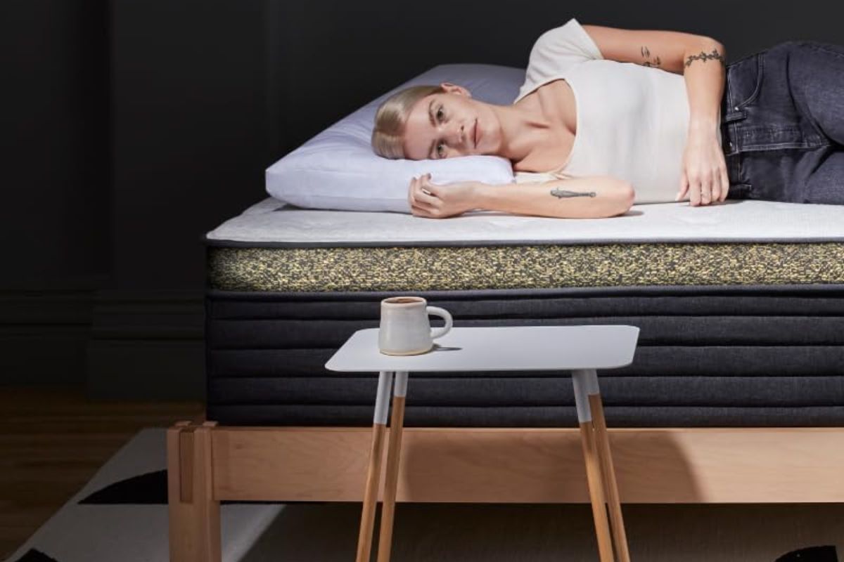 A person laying down on a hybrid mattress.