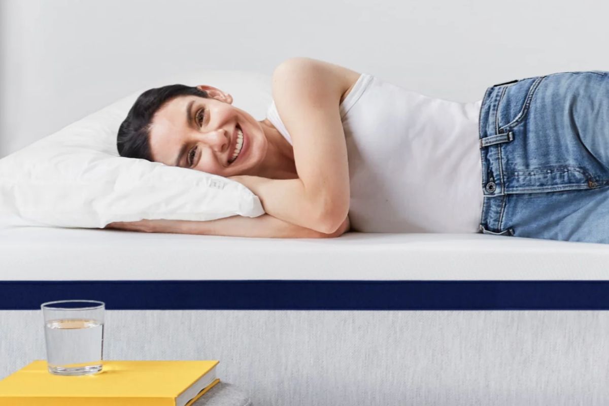 Smiling user resting on Helix Midnight mattress highlighting satisfaction during trial period