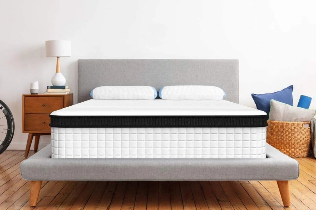 full xl mattress on modern upholstered bed frame in minimalist bedroom with wooden floors and bedside table