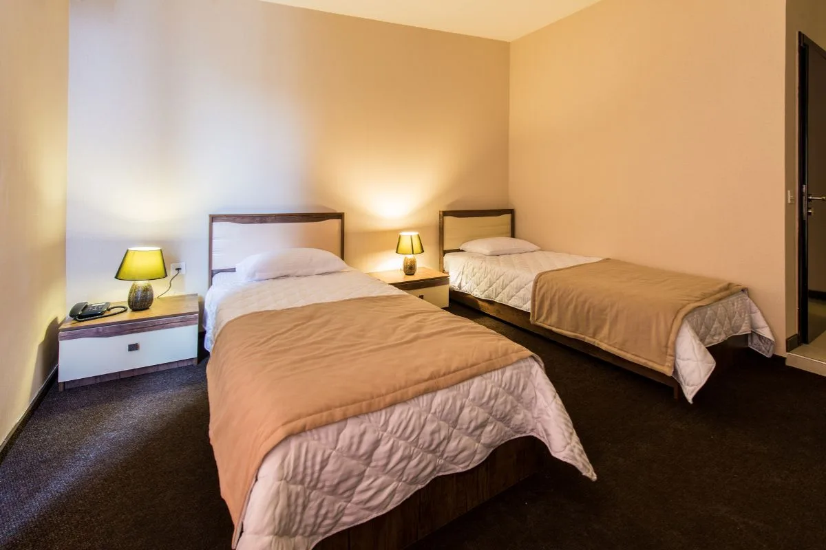 Twin beds in a room showing typical mattress thickness and depth on standard bed frames