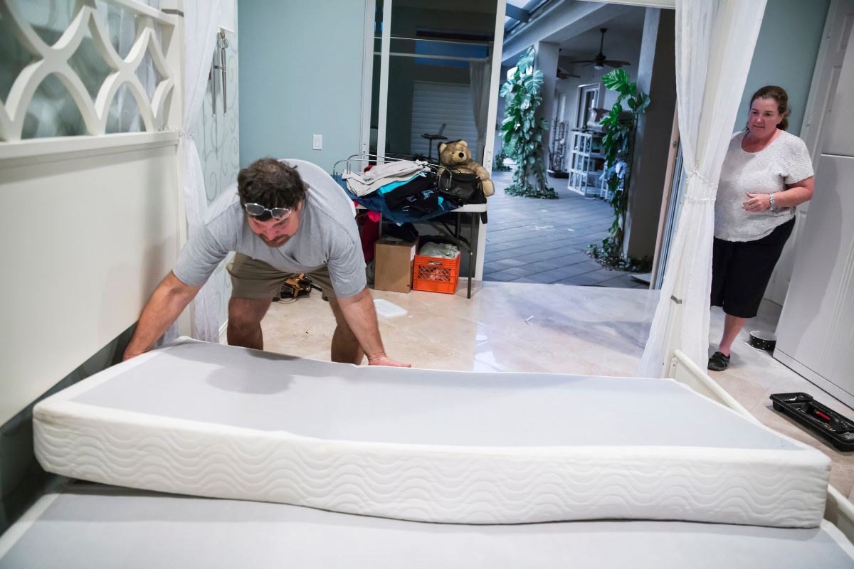 How Much Does a Full Size Mattress Weigh? Person carrying a mattress through a room showing how heavy a full size mattress can be to move