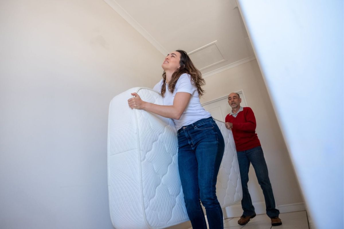 How Much Does a Twin Mattress Weigh? People carrying a mattress upstairs showing typical weight and portability of a twin mattress