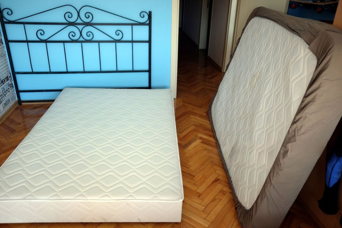 How Much Does a Twin Mattress Weigh? Twin mattress being lifted and positioned on a bed frame demonstrating its lighter weight and easy setup
