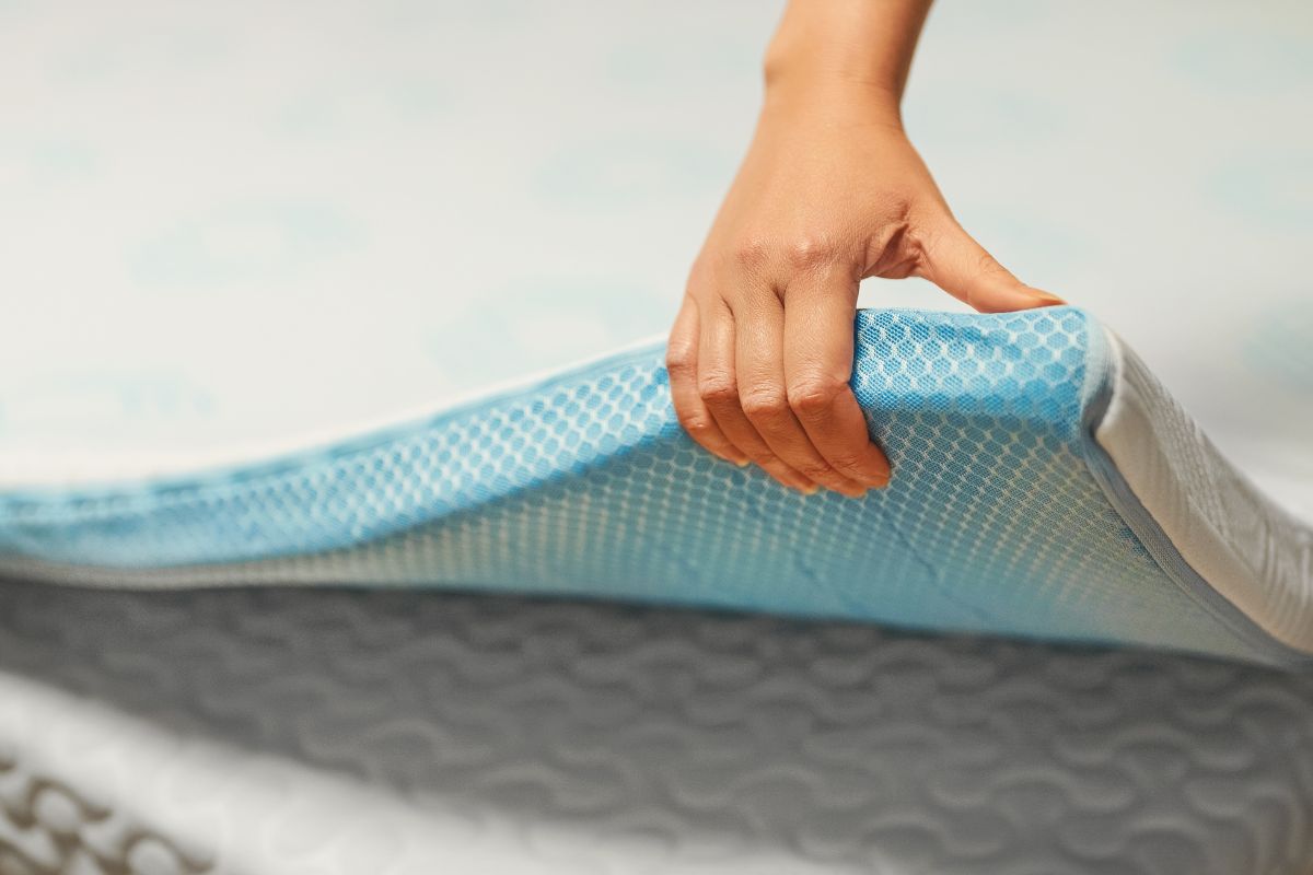 How Much Is a Full Size Mattress? Hand pressing memory foam mattress layer demonstrating material quality and pricing factors