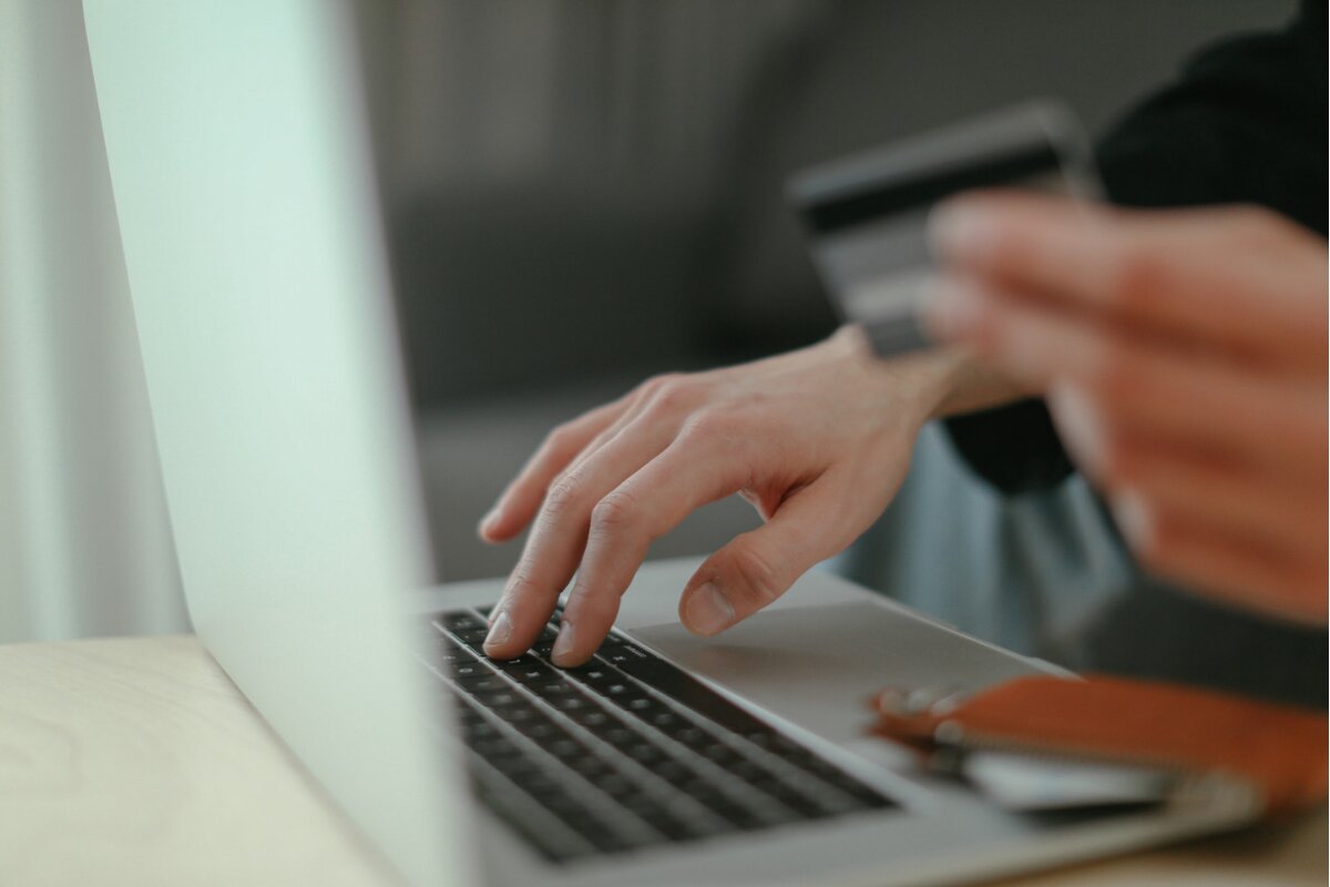 How Much Is a Queen Size Mattress? person using a laptop and credit card to explore financing options for a queen size mattress
