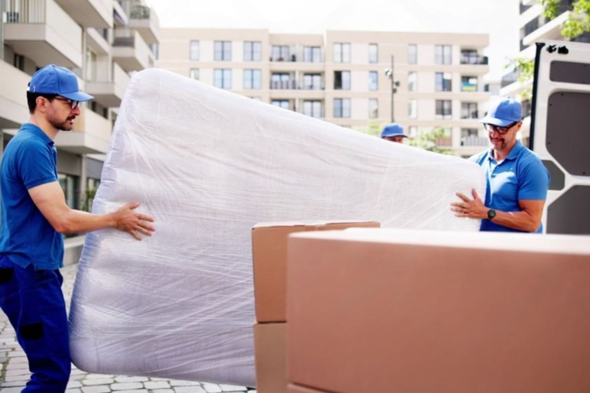How to Transport a Full Size Mattress Like a Pro? Delivery team loading a wrapped full size mattress into a truck for safe transport