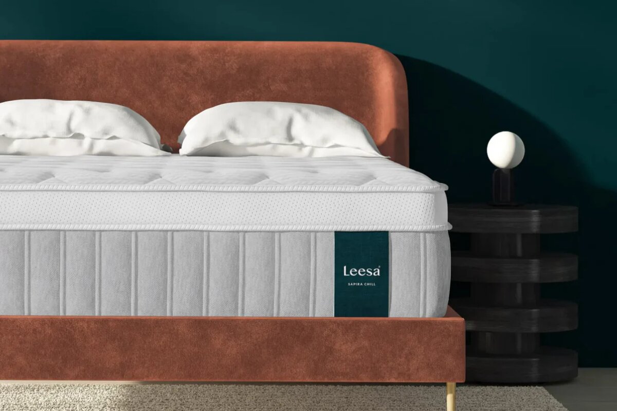 How Safe is the Leesa Sapira Chill Hybrid Mattress? Facts Revealed leesa sapira chill hybrid mattress on a brown upholstered bed frame with white pillows and a dark green wall background