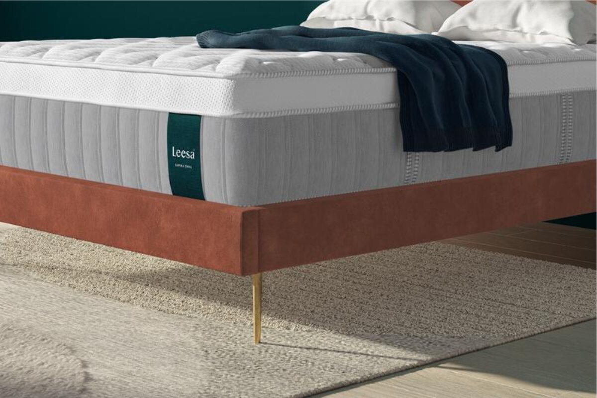 side view of the leesa sapira chill hybrid mattress on a brown upholstered platform bed
