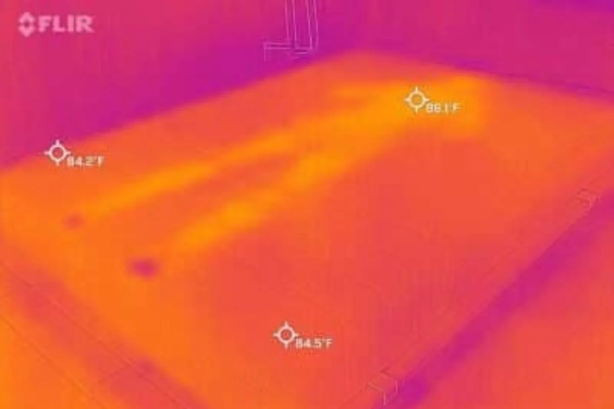 A heat image of a bed where a person laid down on it, barely visible.