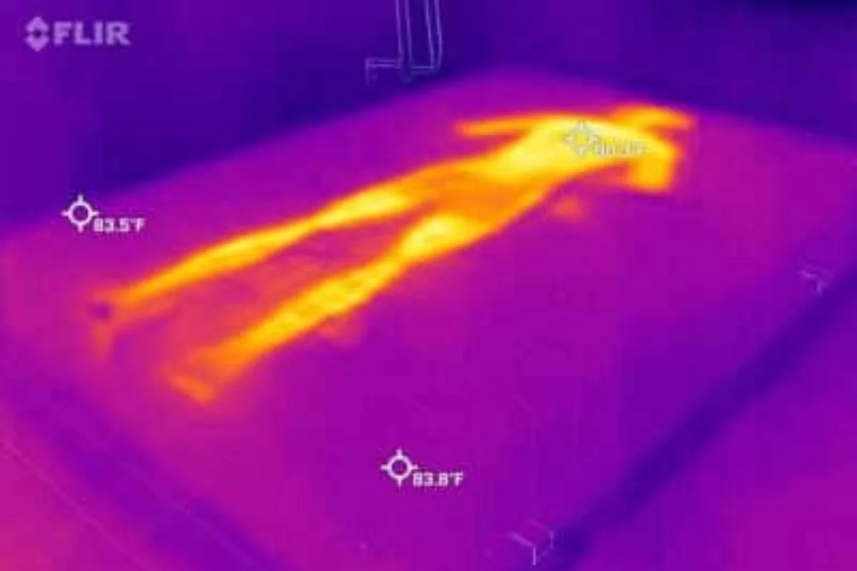 A heat image of a bed where a person laid down on it, very visible.