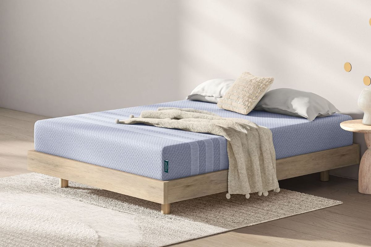 The Leesa Studio mattress in a cozy bedroom with pillows and a blanket.