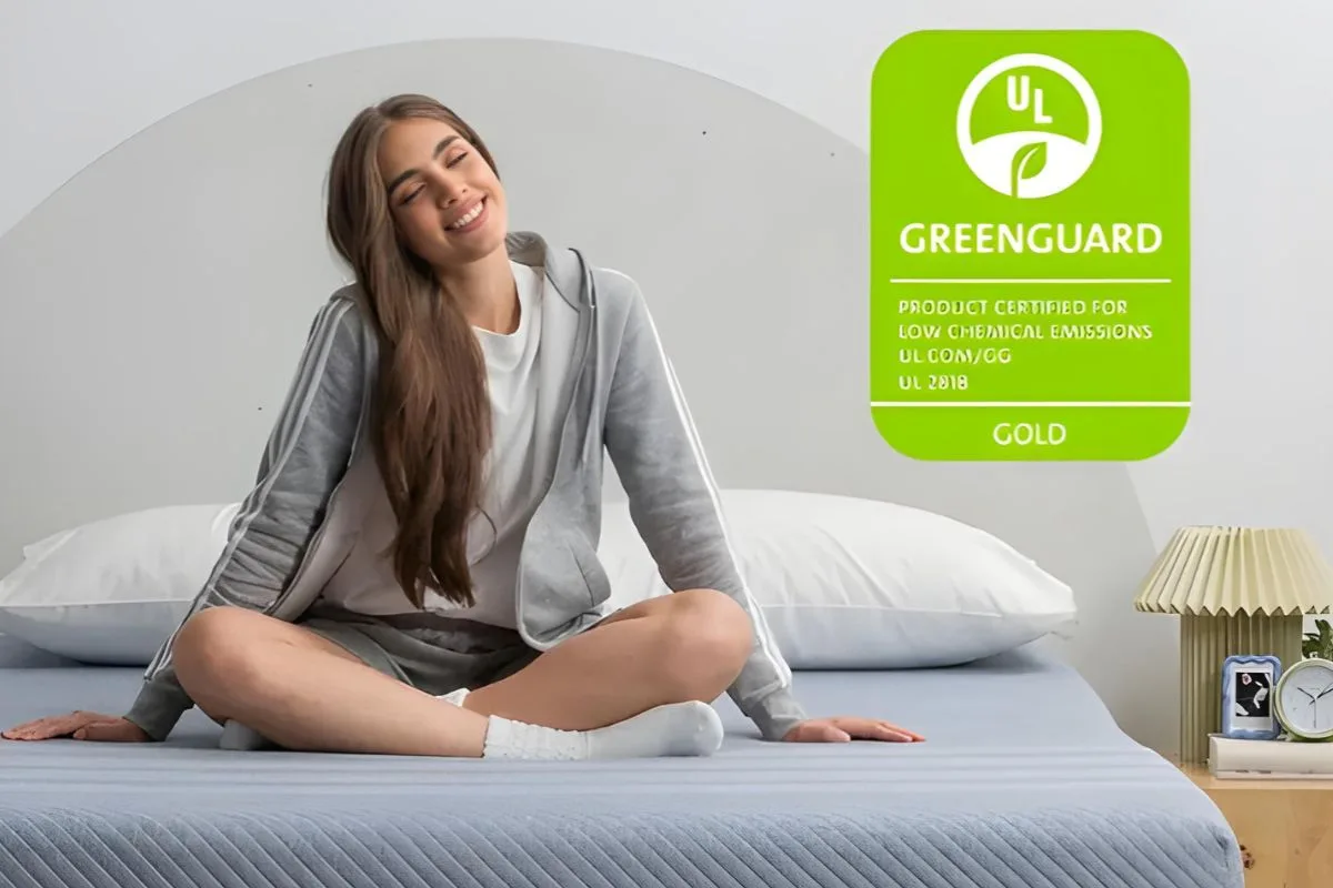 User sitting comfortably on Leesa Studio mattress with GREENGUARD certification highlighting safety and low emissions