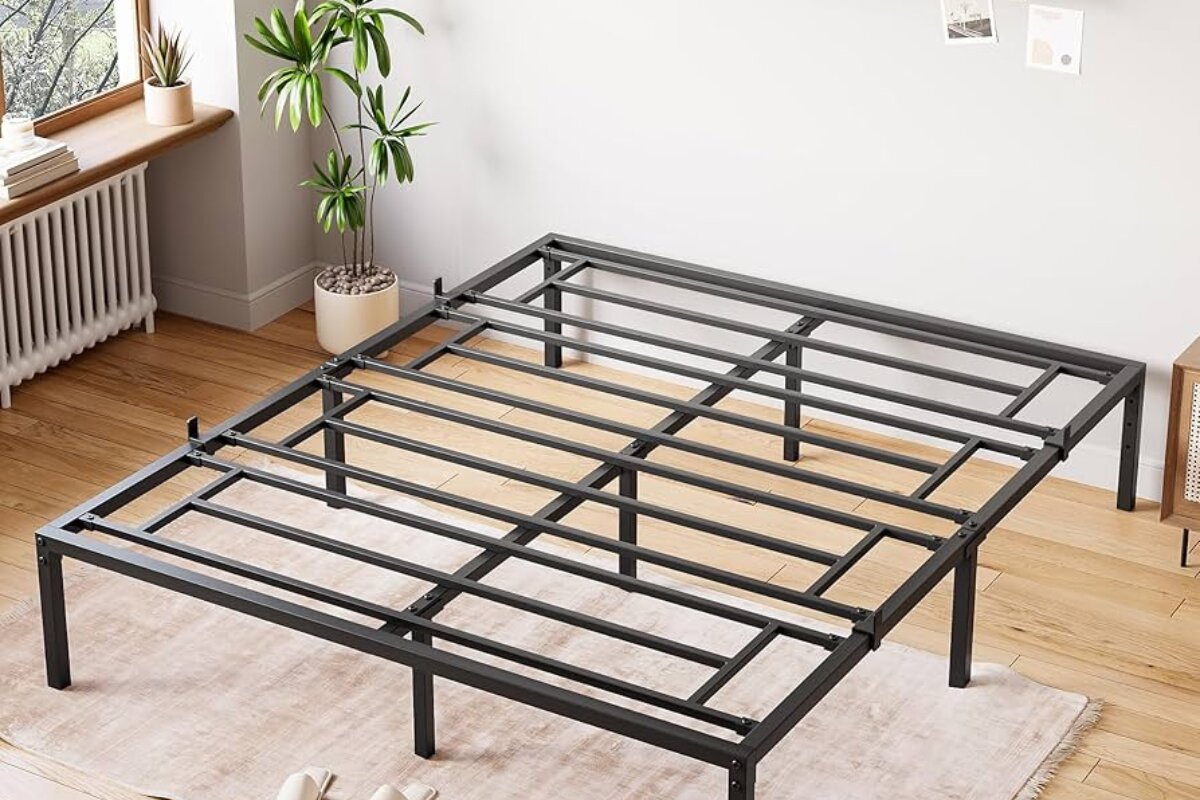 What is a Full Bed? black metal full bed frame with sturdy slat support in minimalist bedroom with wood flooring and indoor plants