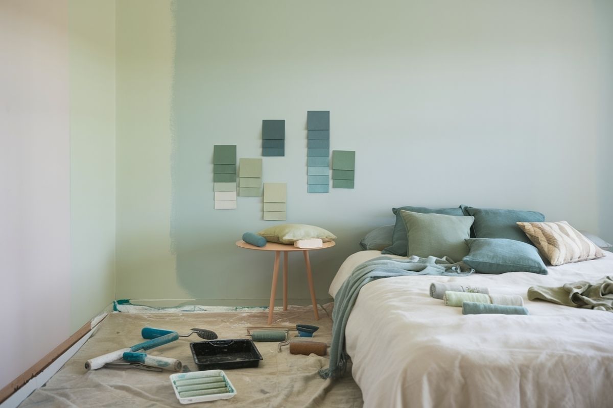 Pale green bedroom walls with matching decor showing how muted earth tones can create a relaxing sleep environment