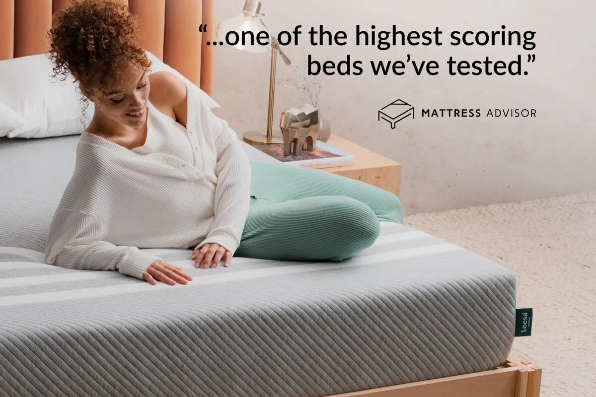 A woman lying down on the Leesa Original Mattress with a comment from mattress advisor "one of the highest scoring beds we've tested".