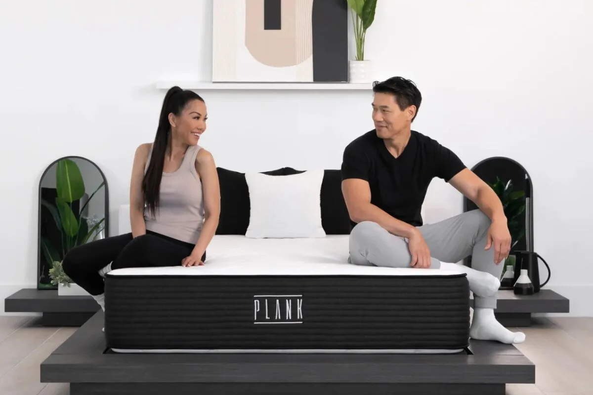 plank mattress with two people sitting on opposite sides demonstrating motion isolation and support