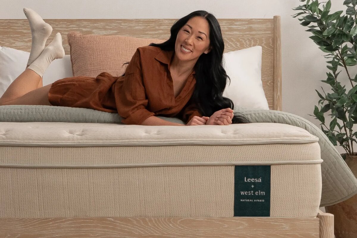 A woman laying on top of the Leesa Natural Hybrid Mattress.